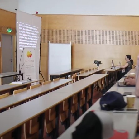 Céline assise à une table tape à l'ordinateur le sous-titrage retransmis