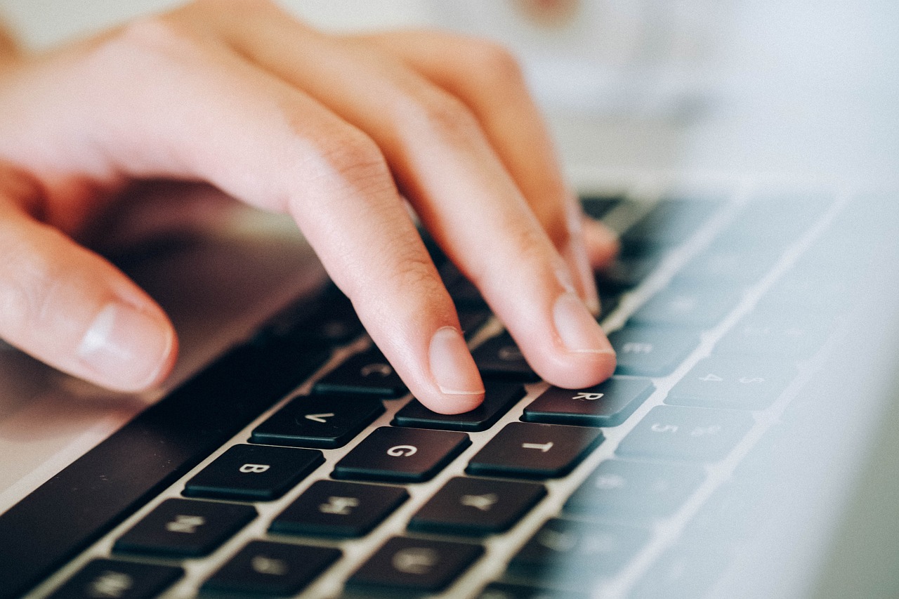 une main écrit au clavier une main écrit au clavier